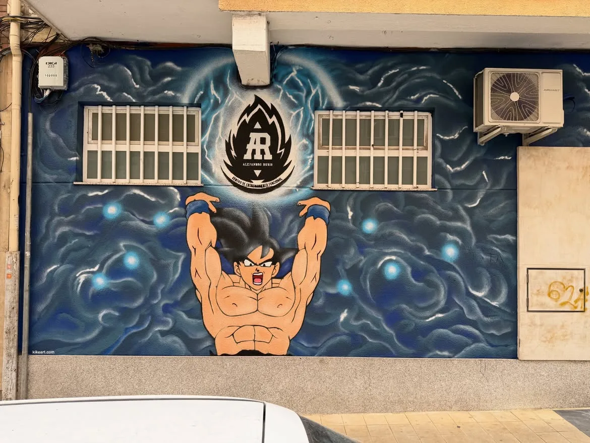 Mural de la fachada del centro: Goku reuniendo energía bajo el logo AR