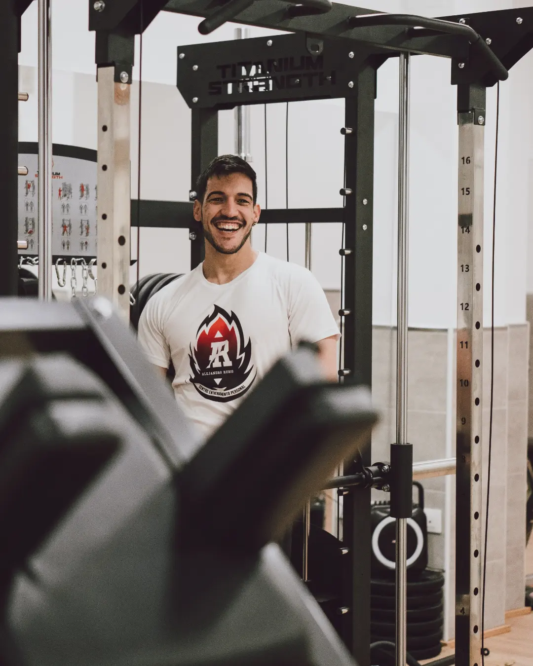 Alejandro sonriendo junto al rack de entrenamiento